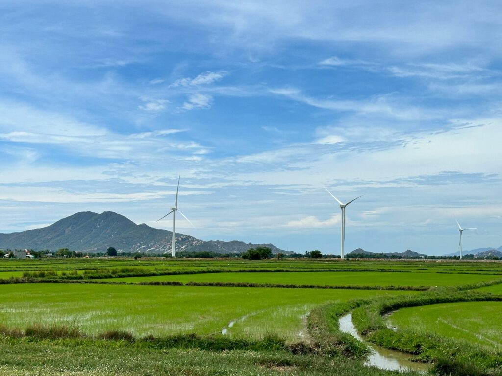 A green field with windmills in the distance